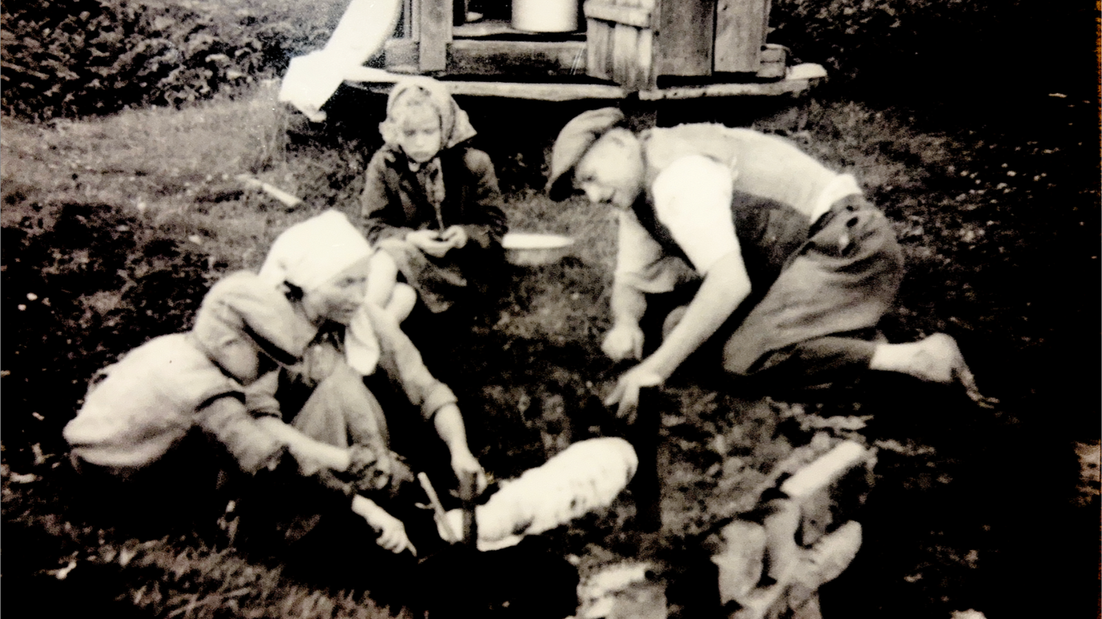 Sena nuotrauka, kurioje Rugelio šeimos nariai kepa šakotį